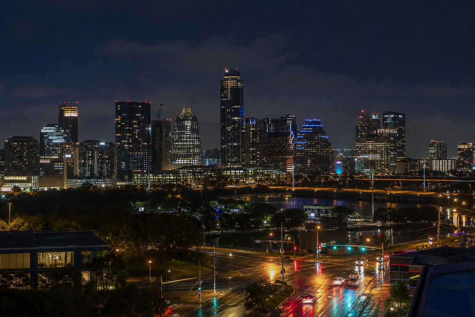 Downtown Austin at night, wet streets and the skyline over Lady Bird Lake.